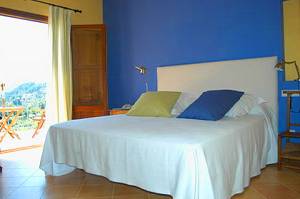 Zimmer mit Doppelbett und Zugang zur Terrasse