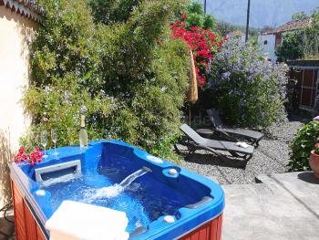 Kleiner Garten mit Jacuzzi und Sonnenliegen