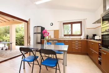 Einbauküche mit Esstisch und Zugang zur Terrasse