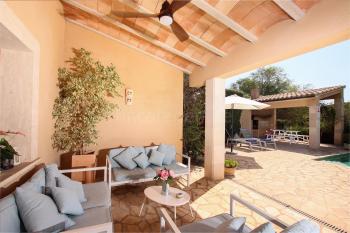 Lounge-Ecke auf der überdachten Terrasse mit Deckenventilator