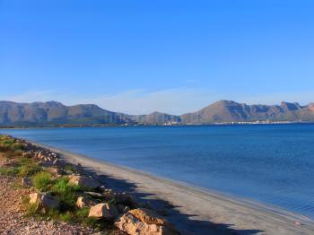Strand von Port d'Alcúdia mit Blick auf die Berge im Norden Mallorcas