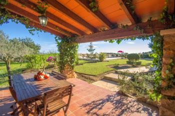 Grillterrasse mit Blick zum Pool und Garten